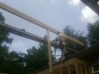 Carpenter setting a ridge beam over a new addition frame — Ice Dam Removal by Roofing Brothers in Schaghticoke