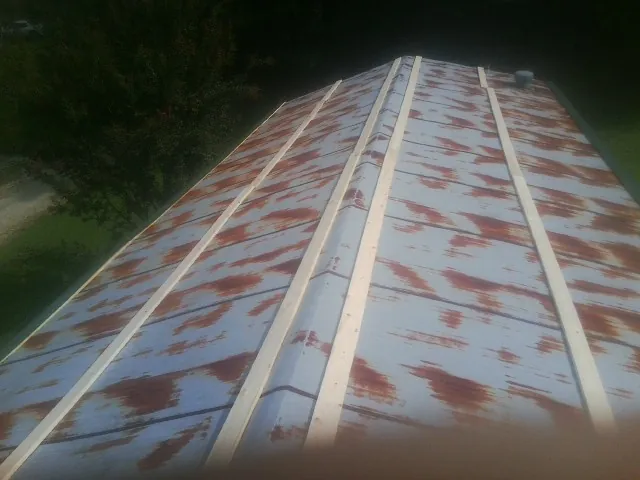 Rusted metal roof panels with new wood purlins before replacement — Storm Damage Roof Repair in Schaghticoke by Roofing Brothers