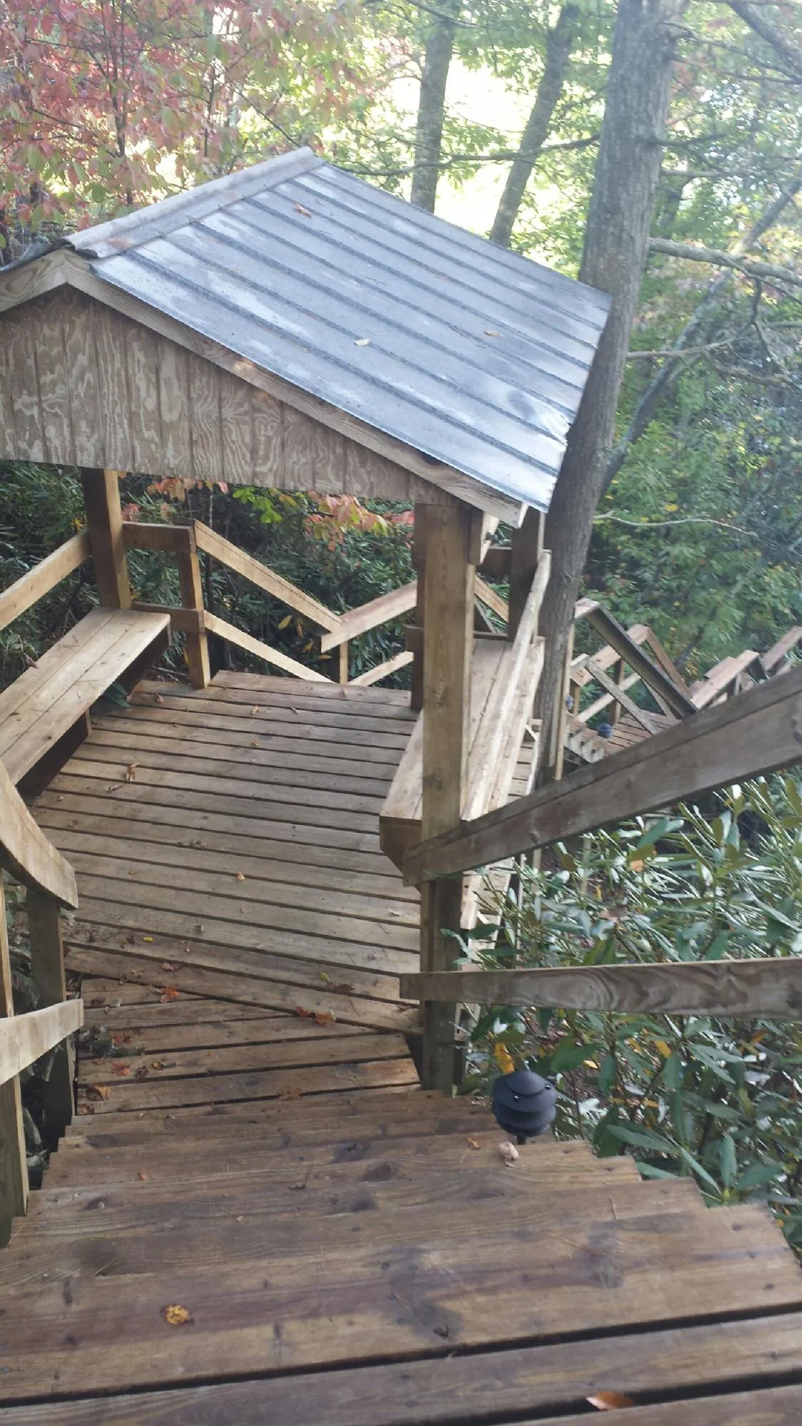 Metal roofed shelter over wooden steps on a wooded walkway — Skylight Repair & Installation work by our crew in Schaghticoke